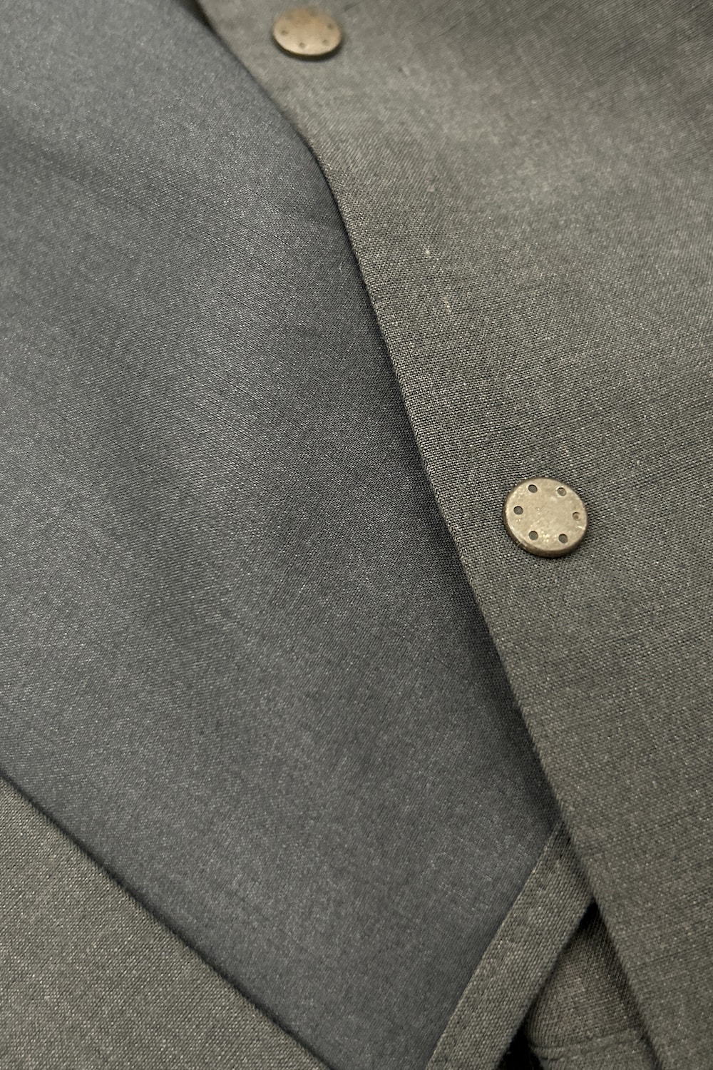 Close-up image showing the vintage-style snap buttons and double-layered front structure
