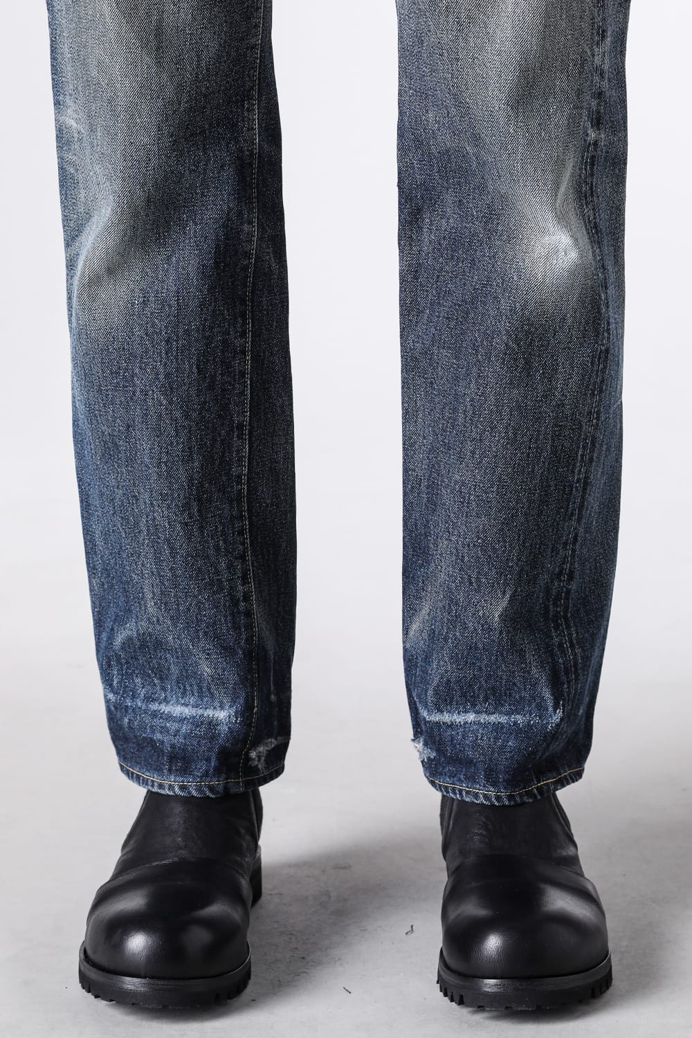 TCB S40's Jeansの裾を下ろして黒い革のブーツに合わせた足元