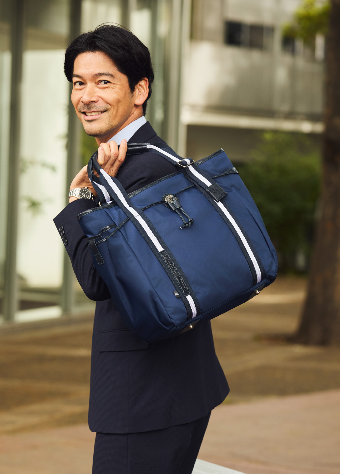 アリンナ 30th トートバッグ、モヴェンツァ スーツケースを手にするHIROYUKI KUBOTA